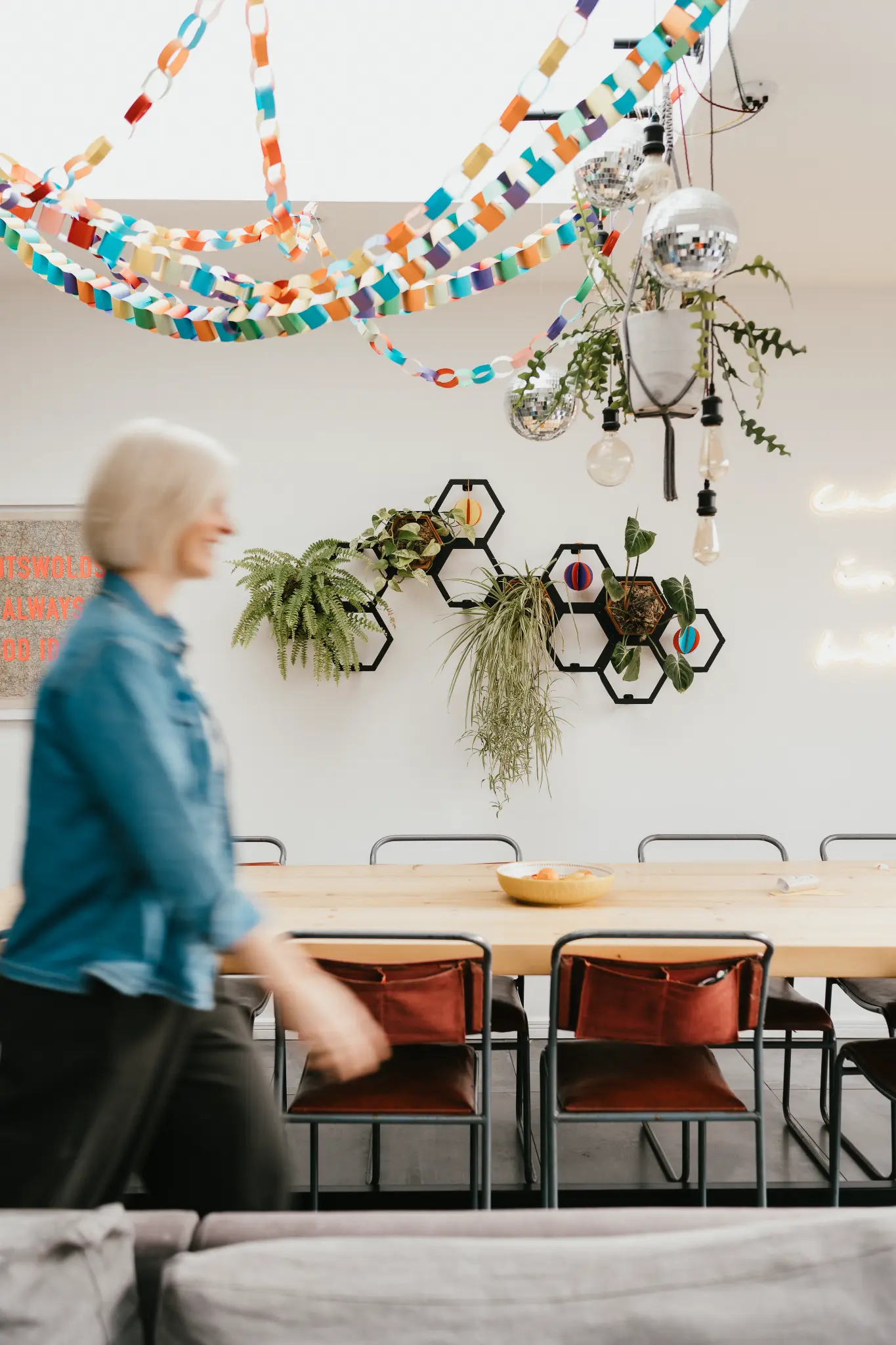 Lucy Nash smiling under a neon sign in a warm kitchen