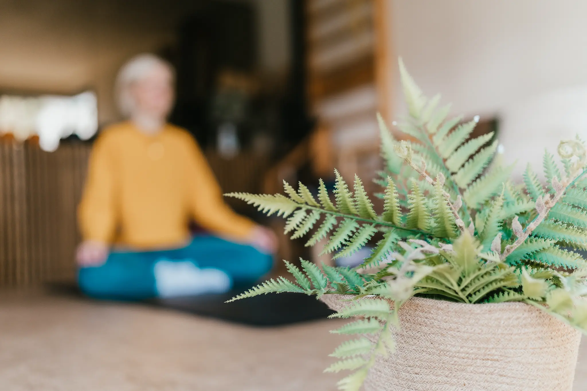 Lucy Nash sitting cross-legged on a yoga mat